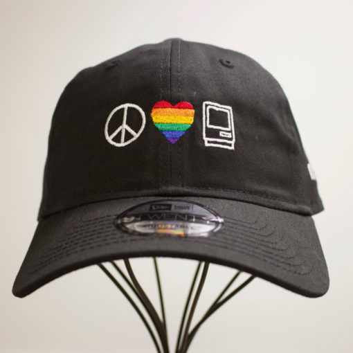 Macstock Hat Pride - Peace Love Mac logo in white. Heart in rainbow colors.